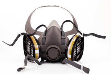 Reusable half-face elastomeric respirator for air purification with replaceable filters on a white background
