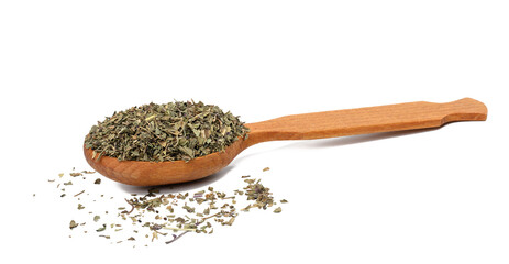 Crushed basil leaves in a brown wooden spoon