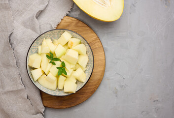Sliced pieces of melon in a round gray plate on the table