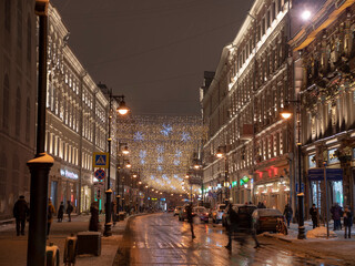 Fototapeta na wymiar Golden rain of Christmas decorations hanging from the sky, on Nikolskaya street in Moscow