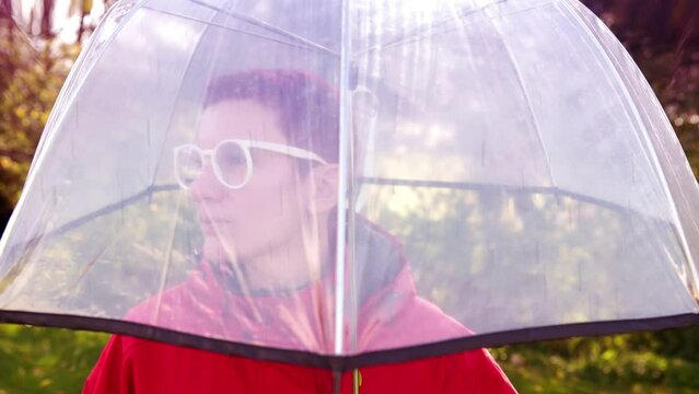 Cinemagraph of woman standing in rain with umbrella
