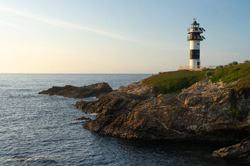 Fototapeta na wymiar Pancha island lighthouse at sunset in Ribadeo coast, Lugo province, Galicia, Spain