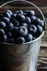 Blueberries in metal bucket dark background