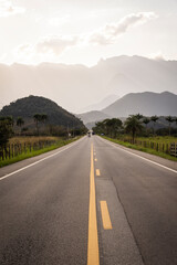 Beautiful coutryside road leading towards wall of high mountains