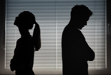 Silhouette of stressed, sad, depressed man and woman 