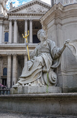 London, England, UK - July 6, 2022: St. Paul's Cathedral. Britannia figure at Statue of Queen Anne on West churchyard. Gray marble with golden trident. Columned facade and pediment as backdrop.