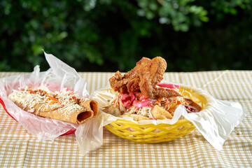 Pollo firto con tajadas servido en una canasta de plastico