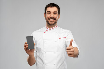 cooking, culinary and people concept - happy smiling male chef with smartphone showing thumbs up...