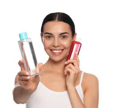 Young Woman With Bottles Of Micellar Water On White Background