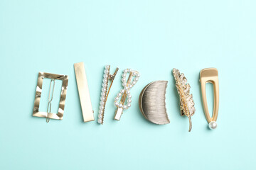 Stylish hair clips on light blue background, flat lay