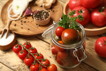 Pickling jar with fresh ripe cherry tomatoes and spices on wooden table