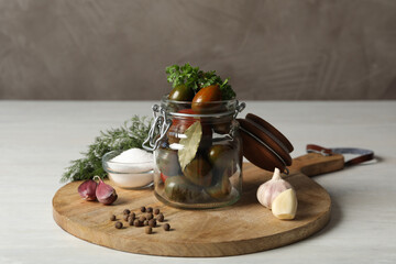 Pickling jar with fresh ripe tomatoes on white table