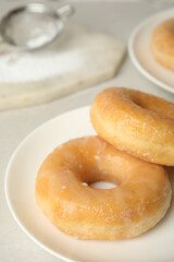 Sweet delicious glazed donuts on light table