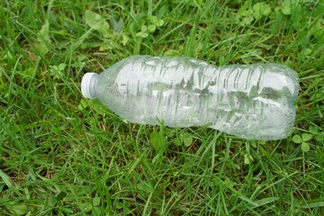 Plastic water bottles thrown on green grass concept campaign to separate plastic waste for recycling