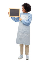 cooking, culinary and people concept - happy smiling woman in apron holding black chalkboard over white background