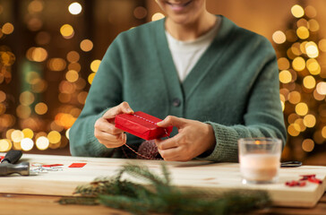 winter holidays and hobby concept - woman with box and rope packing christmas gift or making advent...
