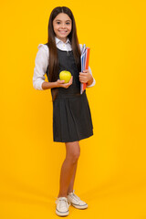 Full length of schoolchild, teenage student girl with school bag backpack hold aplle on yellow isolated studio background. Children school and education concept.