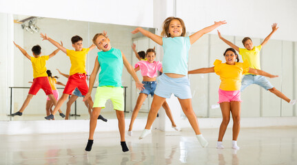 Fototapeta na wymiar Portrait of satisfied boys and girls jumping having fun after dance class