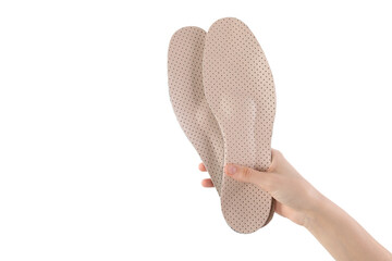 Woman holding pair of pink orthopedic insoles on white background, closeup