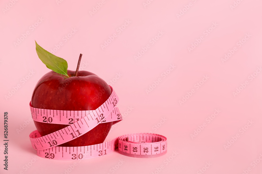 Canvas Prints Fresh red apple with measuring tape on pink background. Space for text