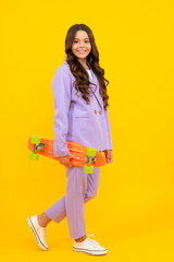 Fashion teenage lifestyle, beautiful teen girl with skateboard isolated on studio background.