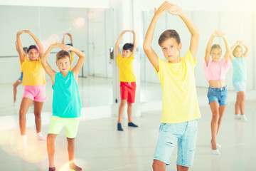 Fototapeta premium Group of kids training dance moves together in studio.