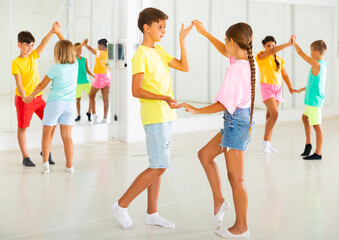 Portrait of active children enjoying of partner dance in class