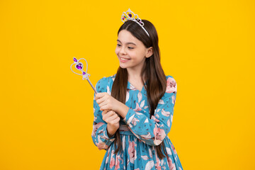 Teenage girl kid princess on yellow background. Romantic wonderland story. Little fairy girl with crown and magic wand putting spell.