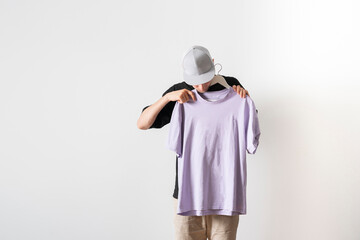 young guy trying on new clothes, isolated on pastel background