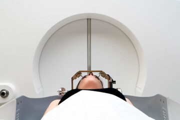 The patient lies in front of the device for the treatment of cancer with a gamma knife. She has a metal clip cap on his head. Gamma Knife stereotactic radiosurgery.