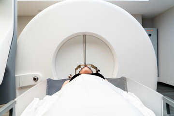 The patient lies in front of the device for the treatment of cancer with a gamma knife. She has a...