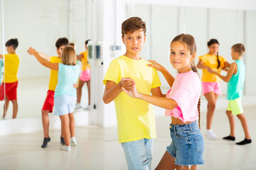 Portrait of active children enjoying of partner dance in class