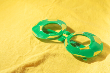 Glasses with Brazil colors, yellow and blue green, world cup concept with yellow background