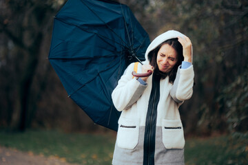 Woman Struggling During Raining Storm Holding an Umbrella. Unhappy girl fighting windstorms...