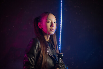 Girl warrior with neon katana in the smoke in the neon lights concept.