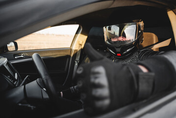 Rally car driver sitting by the steering wheel and showing a thumbs up gesture concept. Good race...