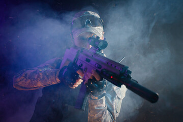 Obraz na płótnie Canvas Futuristic soldier with a rifle on the black smoky background. Action movie film concept.
