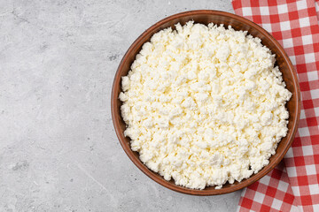 Cottage curd cheese in a wooden bowl grey table background