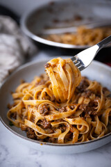 lifting up fettuccine ragu with fork