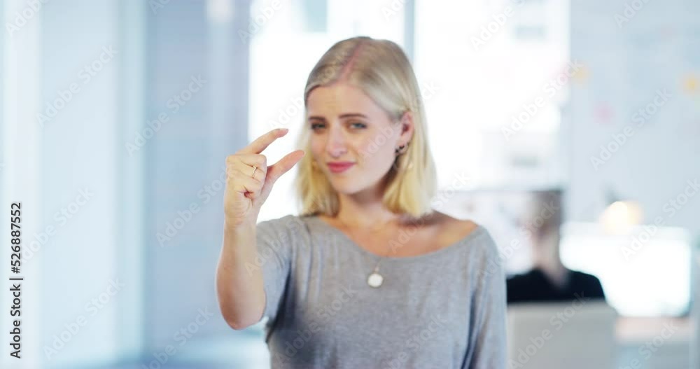Poster portrait of an unsure corporate employee showing a hand sign for small or size while standing in an 