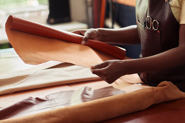 Close up of black female artisan working with genuine leather in workshop, copy space - obrazy, fototapety, plakaty