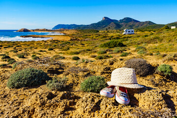 Fototapeta na wymiar Summer hat on coast and camper rv camp on beach in distance