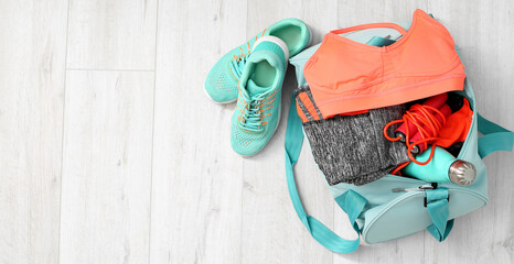 Sports bag and shoes on floor, top view