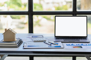 Real estate sales office with example of a house on a businessman's desk.