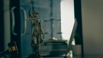 The concept of the law with a judge's hammer and scales. Goddess of Justice with laptop and tiger skins on lawyer's desk.