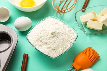 Glass bowl of flour on color background