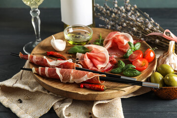 Plate of delicious jamon on dark wooden table
