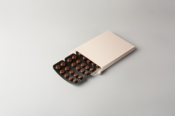 brown blister packs with pills in white box, dark color medical drugs vitamin, antibiotic, pain relievers, package for tablets isolated on gray background