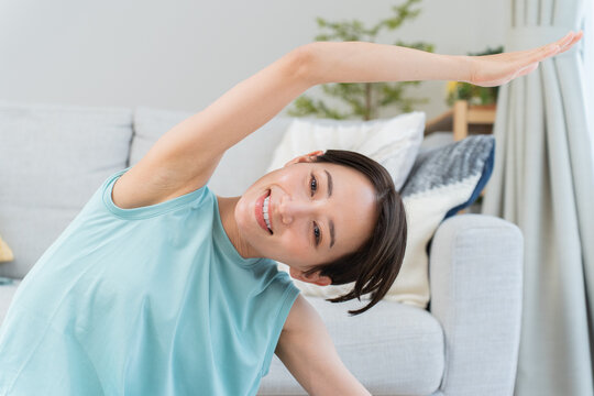 自宅で伸びをする日本人女性