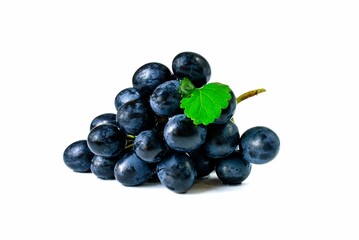 Large bunch of sweet fruit black grapes with green leaves close-up on white background.